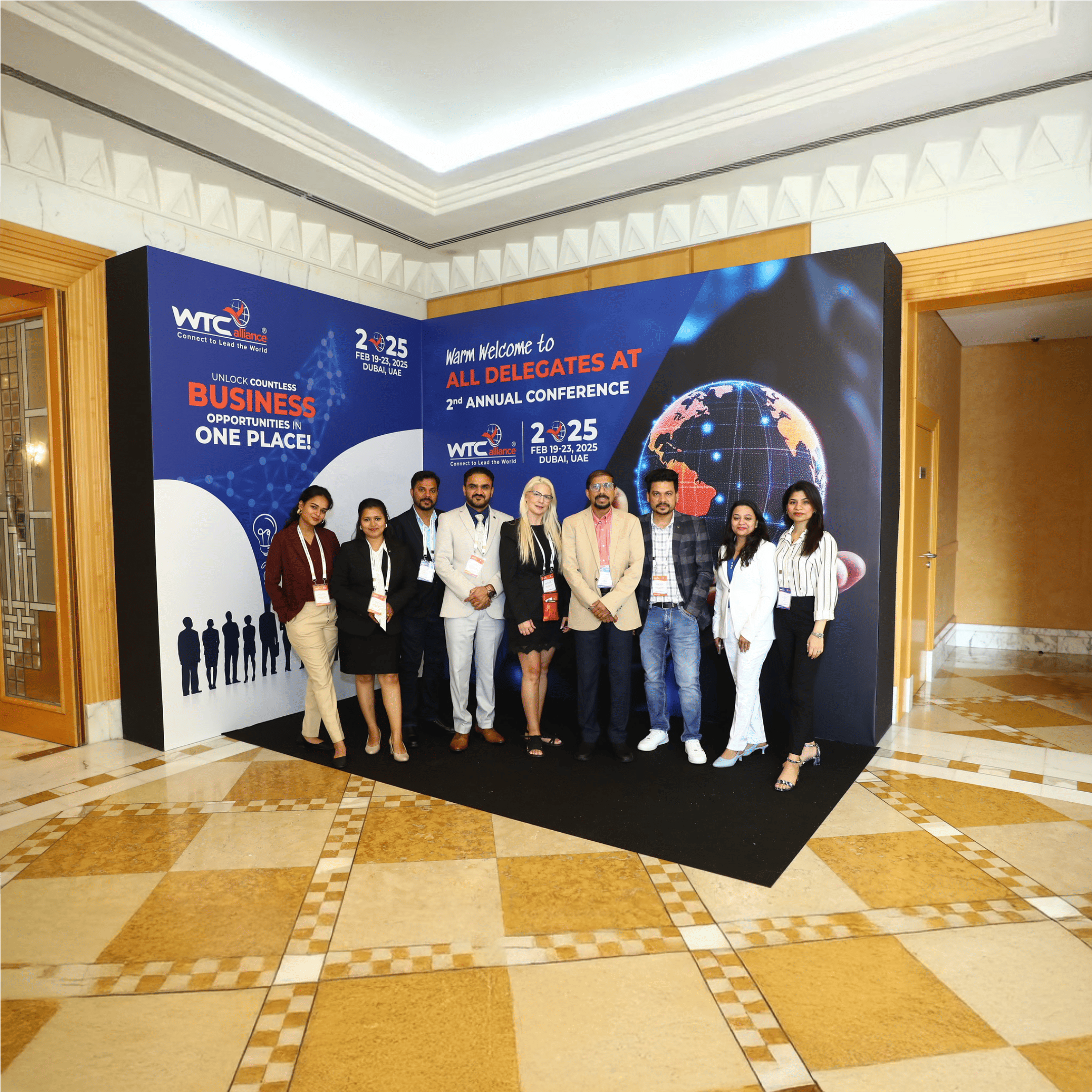 Group photo of delegates standing in front of WTC Alliance conference welcome banner, highlighting a networking event for logistics professionals.